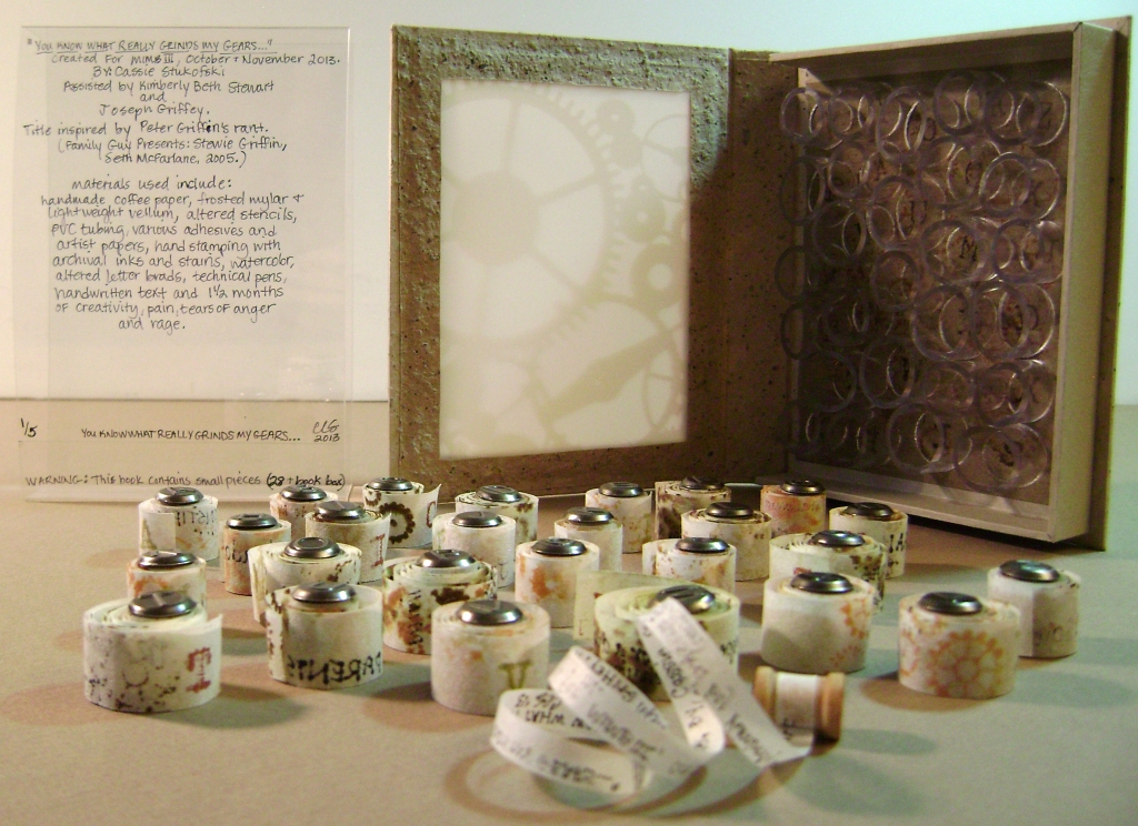 Artist book 1/5 for 'Monumental Ideas in Miniature Books 3' traveling book exhibit.  Twenty-six .25"x19" tiny hand-stamped/ stained/ written mini scrolls & 1 Colophon scroll inside a handmade gearbox covered in handmade coffee paper with translucent front.