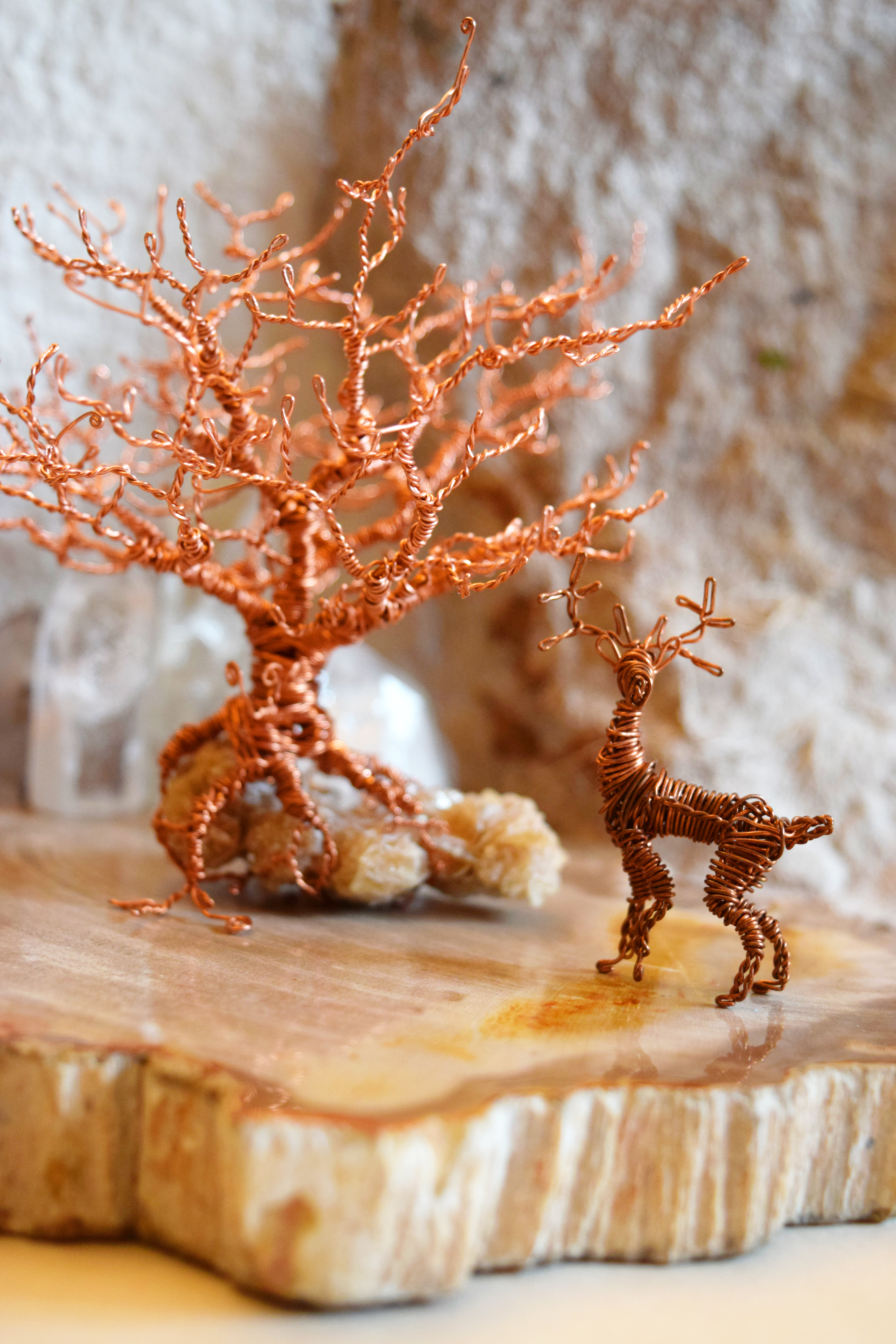 Copper wire, issuing forth from gypsum crystals, twisting together into a tree of gnarled trunk and branches -- hanging over a wire buck in a tentative pose, alert with three hooves on the ground : tree 5 inches tall, deer 1.5 inches tall